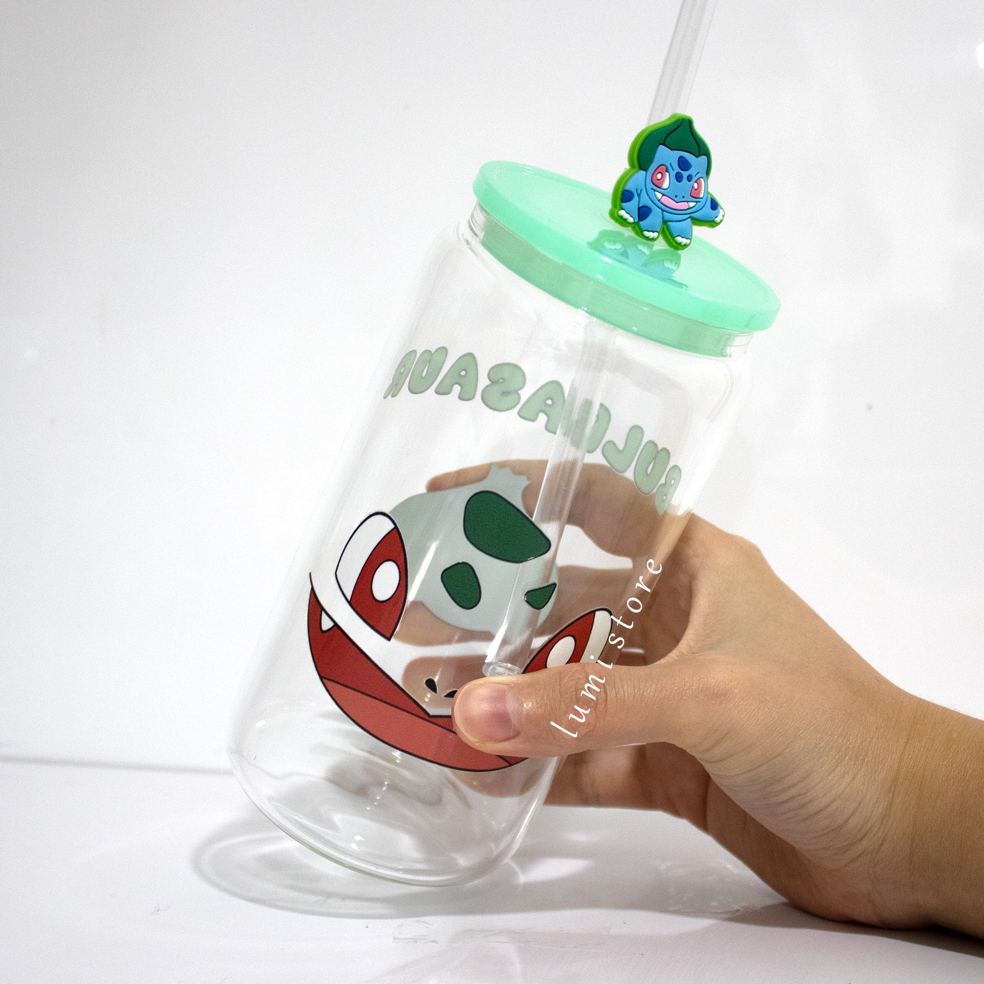 Bulbasaur Glass Tumbler – a Pokemon-inspired 16oz glass cup! 🐉💖 Perfect for Pokemon lovers or a delightful self-indulgence. Each cup is HANDMADE, ensuring a unique piece. Elevate your sipping experience with this Glass Cup featuring a Colorful Lid and Reusable Straw.