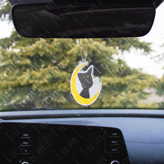 Image of a round air freshener with a colorful design featuring Luna, the black cat from Sailor Moon, on a crescent background